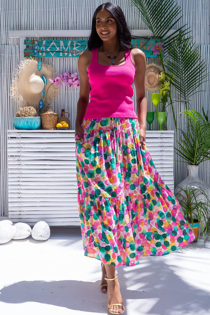 The Valencia Hubbly Bubbly Maxi Skirt features an elasticated waistband with drawstring, a double tiered skirt and side pockets. The Hubby Bubbly Print is a green, pink and yellow print of semi-transparent overlapping spots. Made from a woven blend of cotton and viscose.