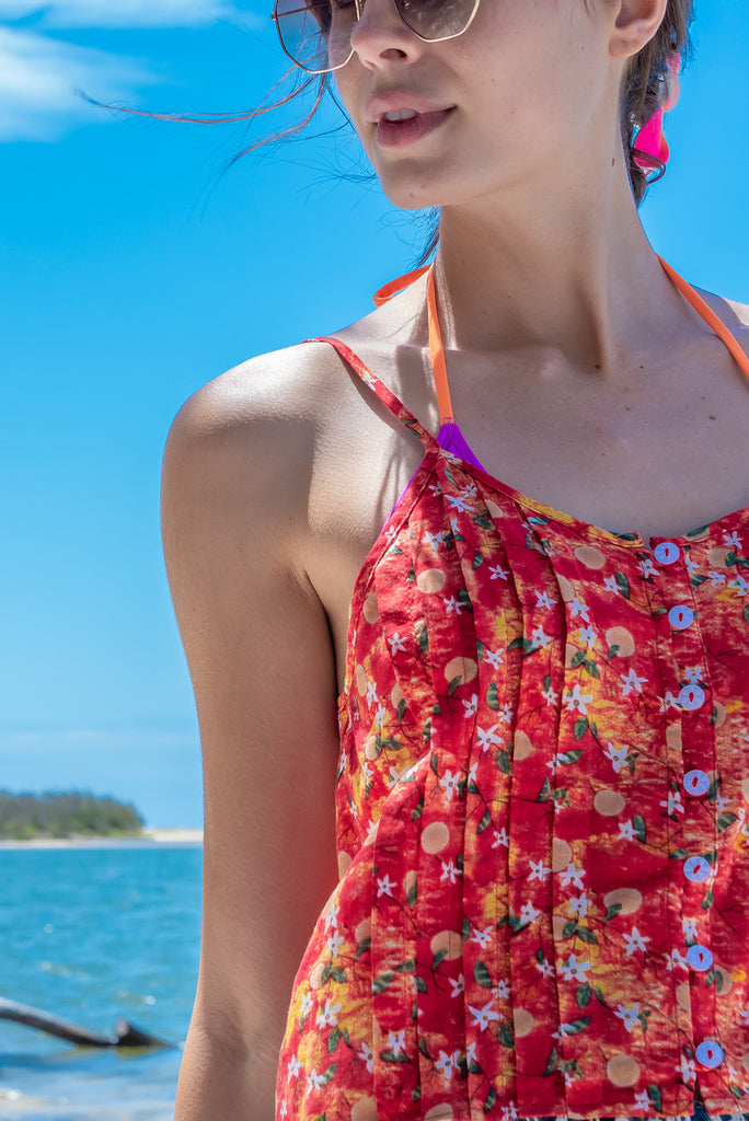 The Valentine Summer Sun Cami Top is gorgeous cami top with a red wash effect base and a fruit vine print. The top features a button front, pintuck features on hem, adjustable thin straps, lace detail on hem and a soft cut. Made from a woven cotton/rayon blend.