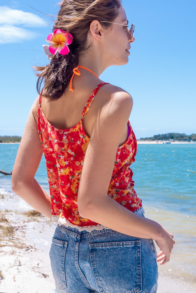 The Valentine Summer Sun Cami Top is gorgeous cami top with a red wash effect base and a fruit vine print. The top features a button front, pintuck features on hem, adjustable thin straps, lace detail on hem and a soft cut. Made from a woven cotton/rayon blend.