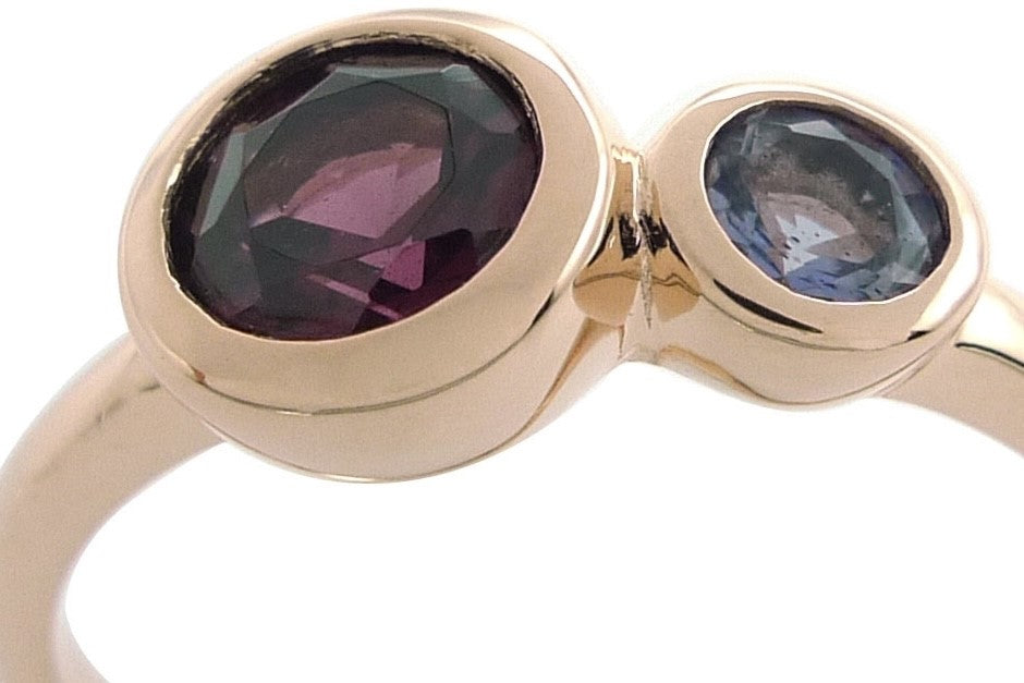 An unusual ring featuring a bright Rhodolite garnet and a smaller Iolite gemstone. Rose gold vermeil setting