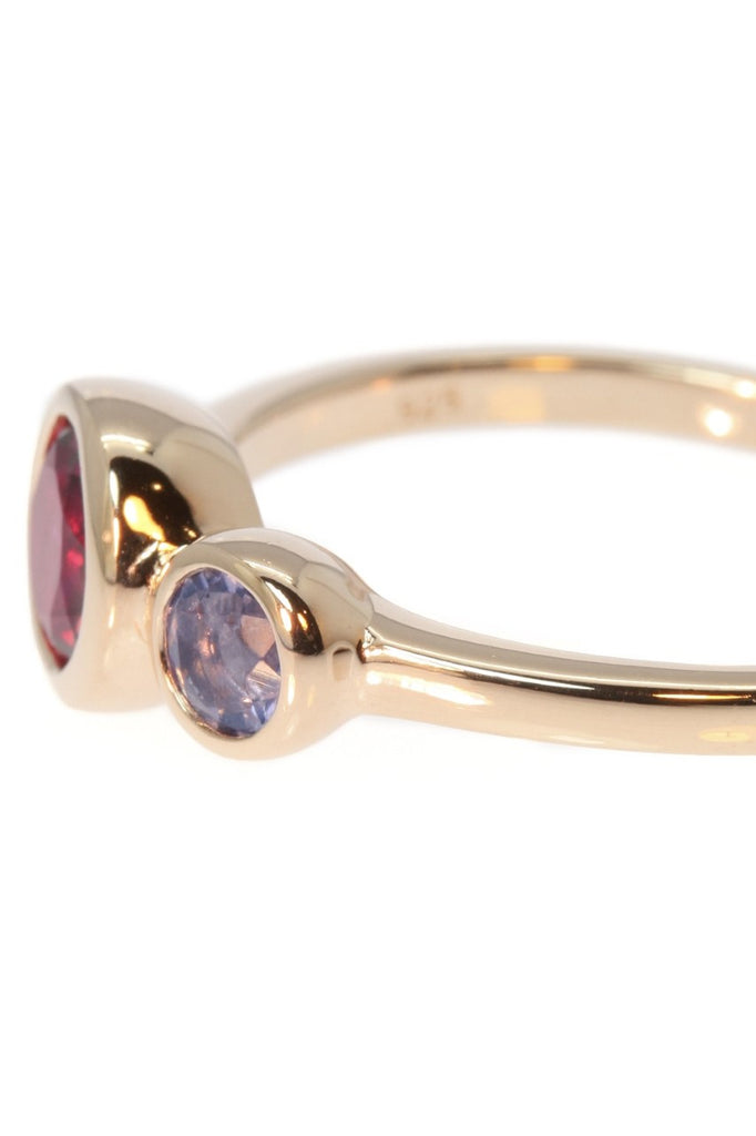 An unusual ring featuring a bright Rhodolite garnet and a smaller Iolite gemstone. Rose gold vermeil setting