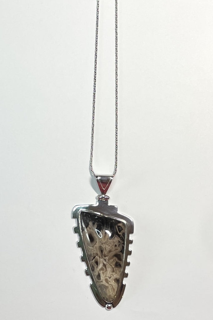 An intriguing fossilized wood pendant reflecting the history of an ancient forest. A modernist setting in a unique design