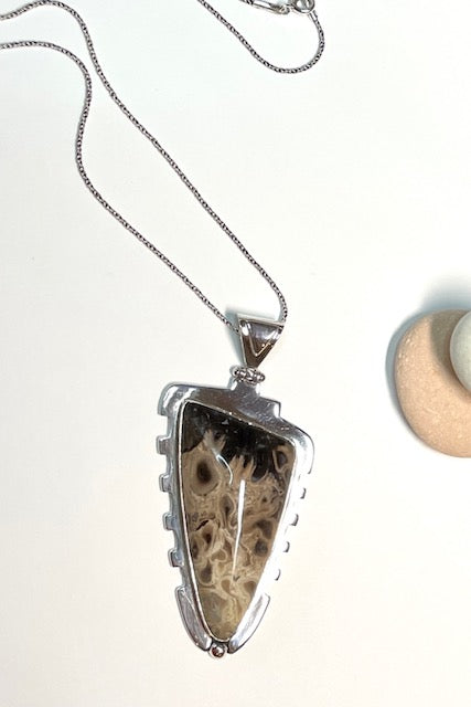 An intriguing fossilized wood pendant reflecting the history of an ancient forest. A modernist setting in a unique design