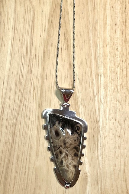 An intriguing fossilized wood pendant reflecting the history of an ancient forest. A modernist setting in a unique design