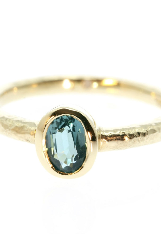 The hammered band on this ring has a slightly textured finish, giving it a hand made feel, complementing the beautiful 6x4mm natural blue tourmaline gemstone set into the ring.