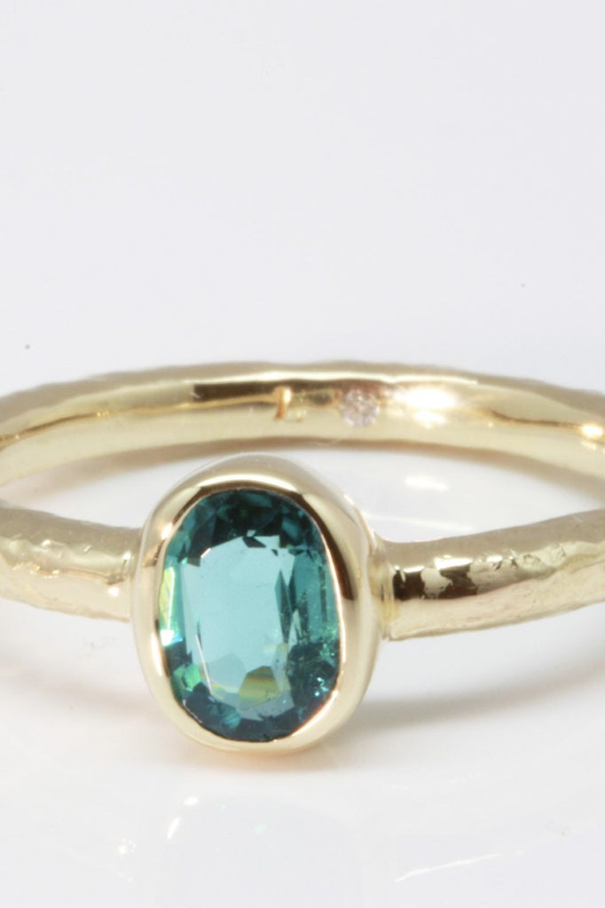 The hammered band on this ring has a slightly textured finish, giving it a hand made feel, complementing the beautiful 6x4mm natural blue tourmaline gemstone set into the ring.