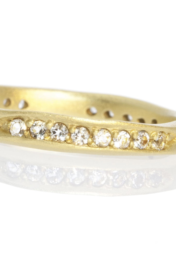 A very unusual and interesting ring, the band has a carved in chanel design which is set with twelve bright sparkling white topaz.