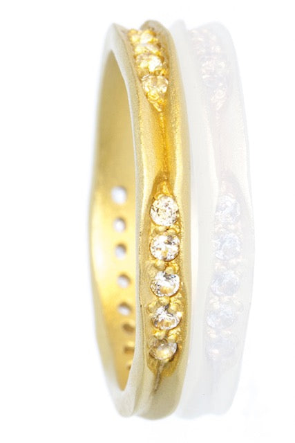 A very unusual and interesting ring, the band has a carved in chanel design which is set with twelve bright sparkling white topaz.