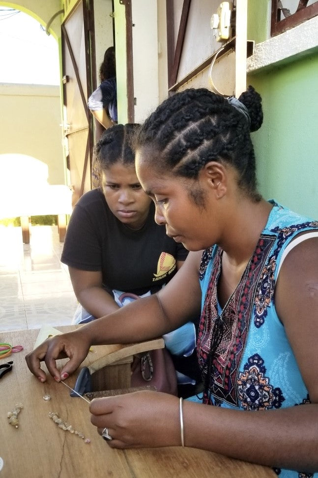 A handmade bangle with a centre piece of Agate stone which has been cut and polished by ROAM Ladies Lapidary Collective in Sakaraha, Madagascar. The band isTigers Eye chip beads. This collective was created with aid funds from the Australia